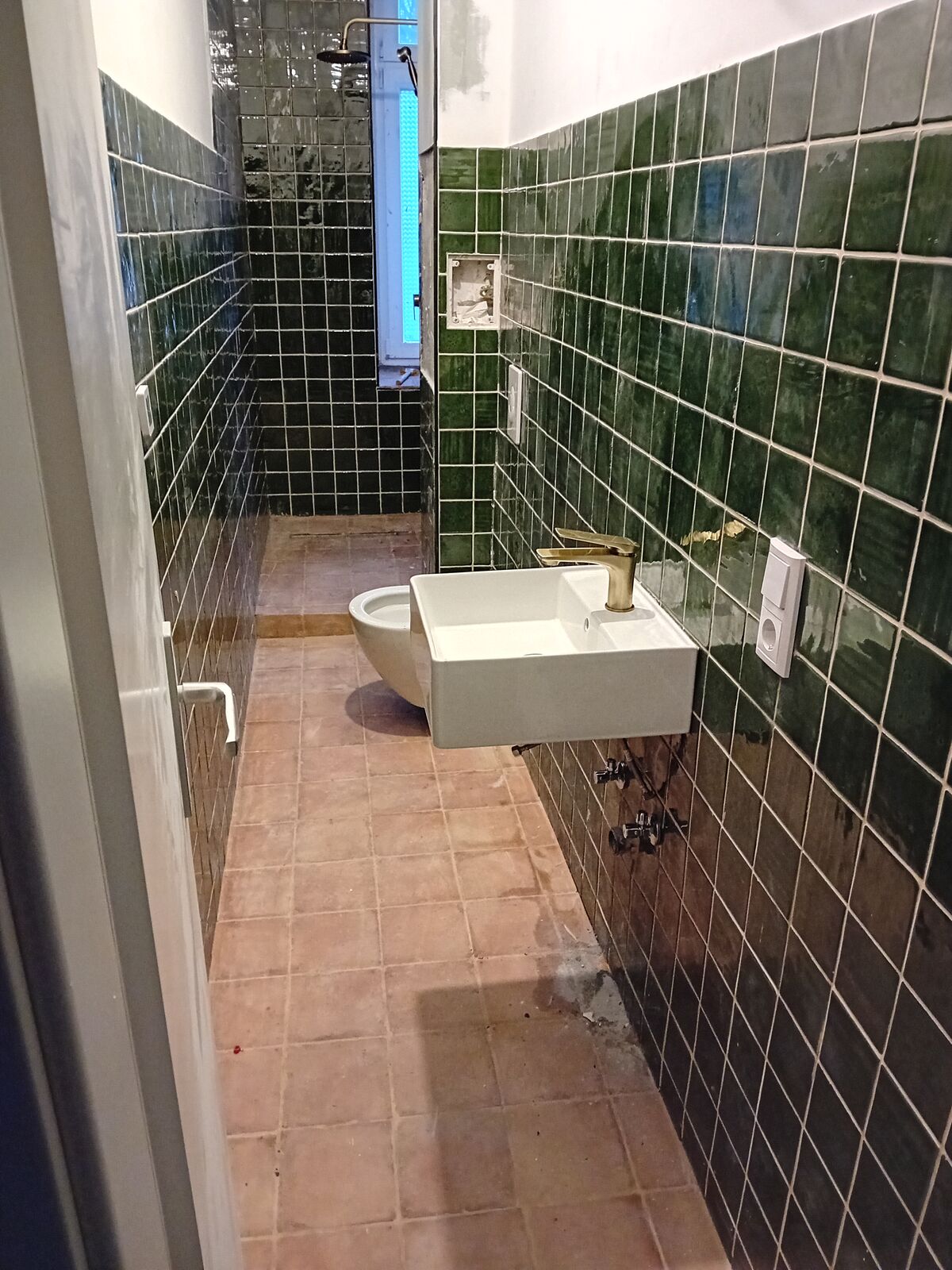 Saniertes Altbaubad mit gruenen Designfliesen
