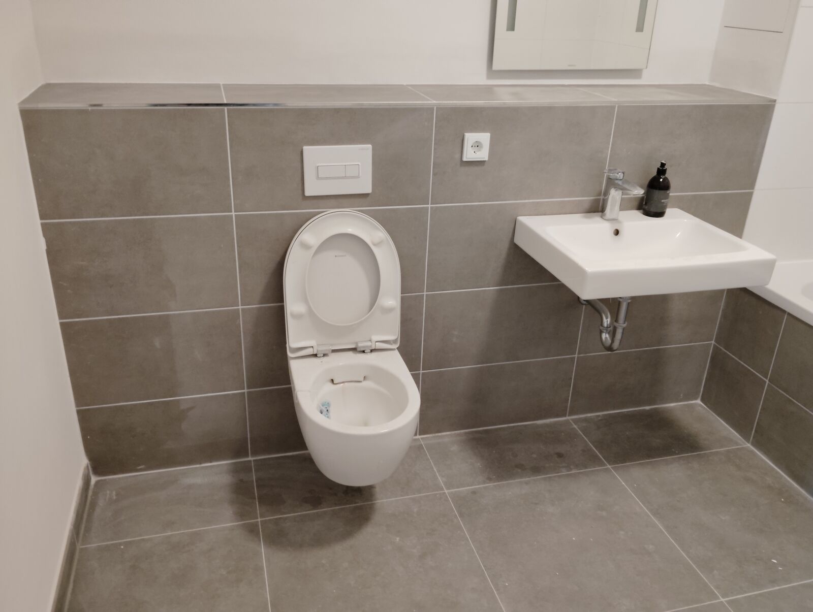 Badezimmer mit WC und Waschbecken vor der Sanierung